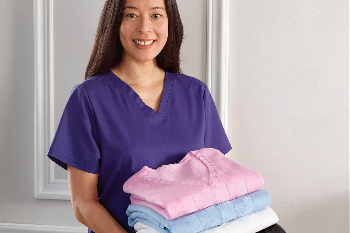 Care worker holding 4 folded cardigans