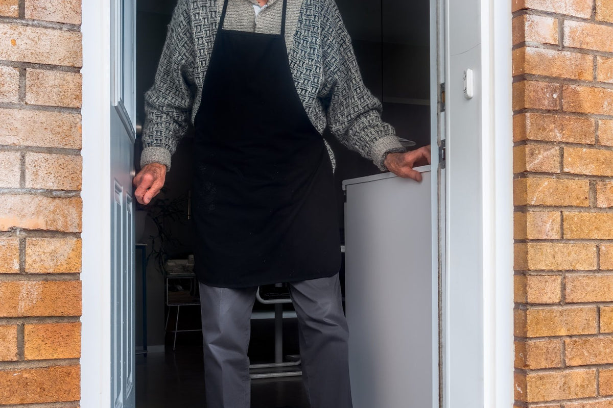 Grandfather is greeted at front door with a gift.