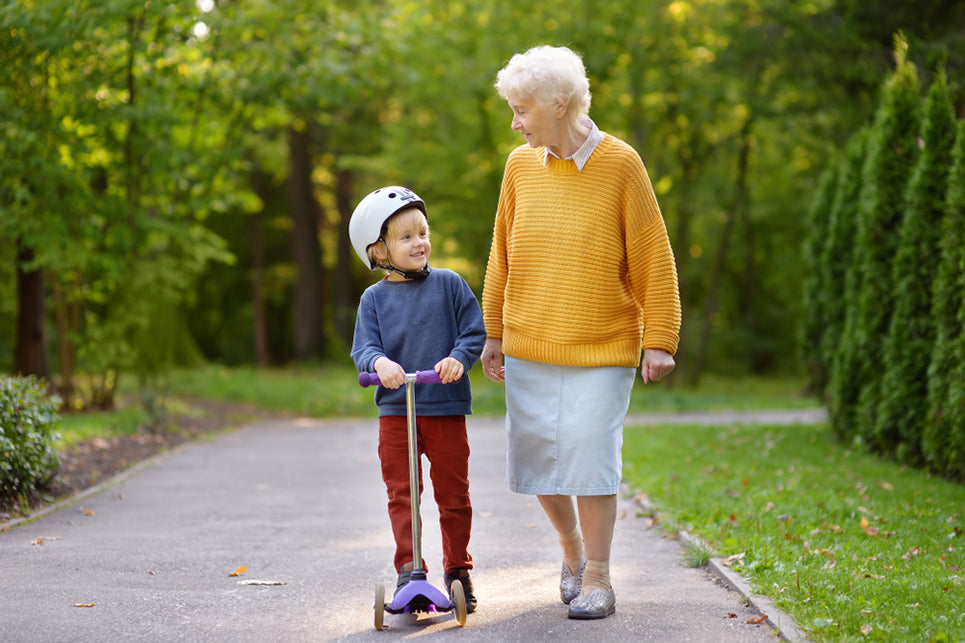 a grandmother and grandchild walking together in a park