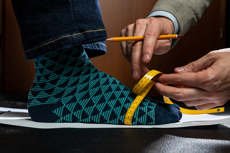 a person measuring the bridge of another persons foot