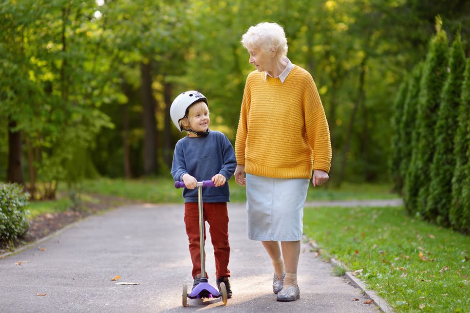a grandmother and grandchild walking together in a park
