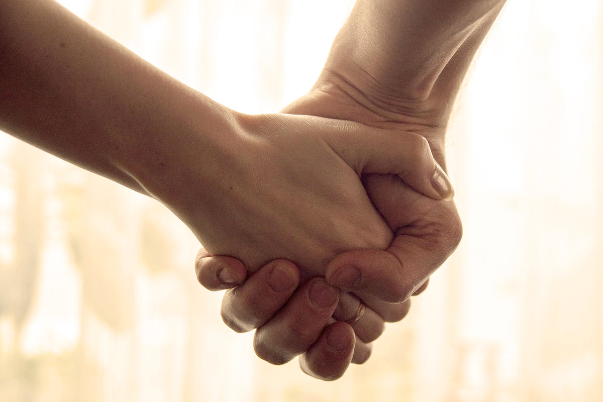 Child holding elderly parent's hand