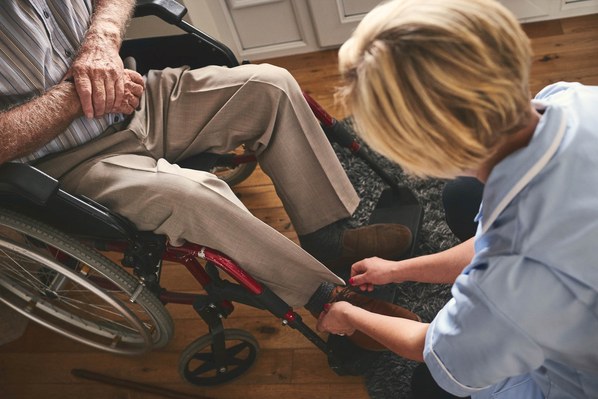 caregiver putting on adaptive footwear