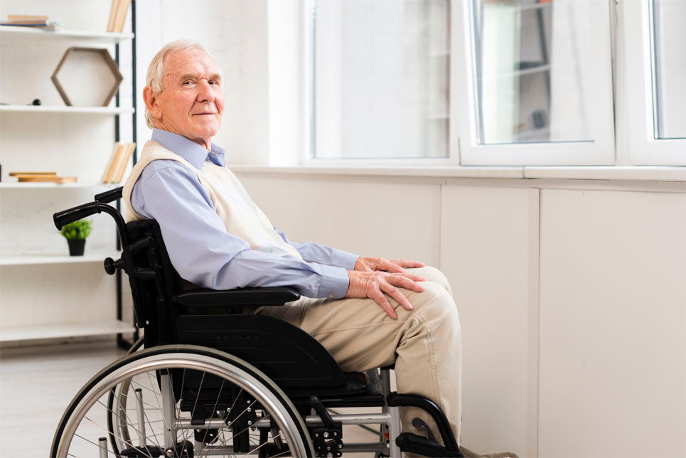 A man sits in a wheelchair, looking at the viewer