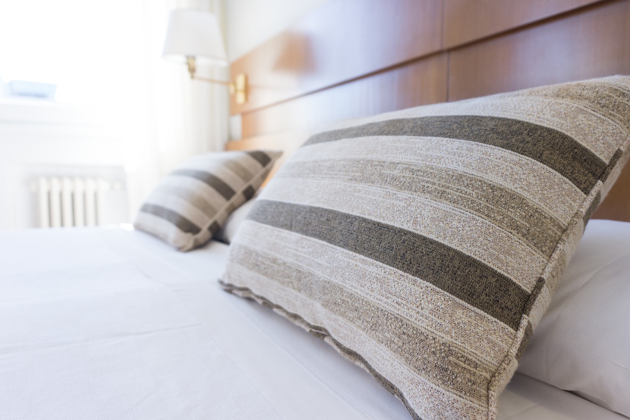 Beige striped pillows on perfectly made bed
